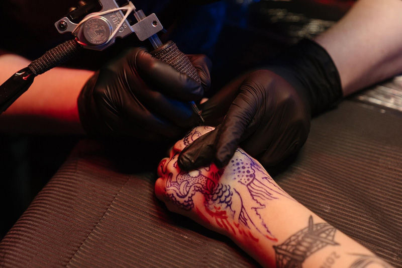 hombre haciéndose un nuevo tatuaje en la mano